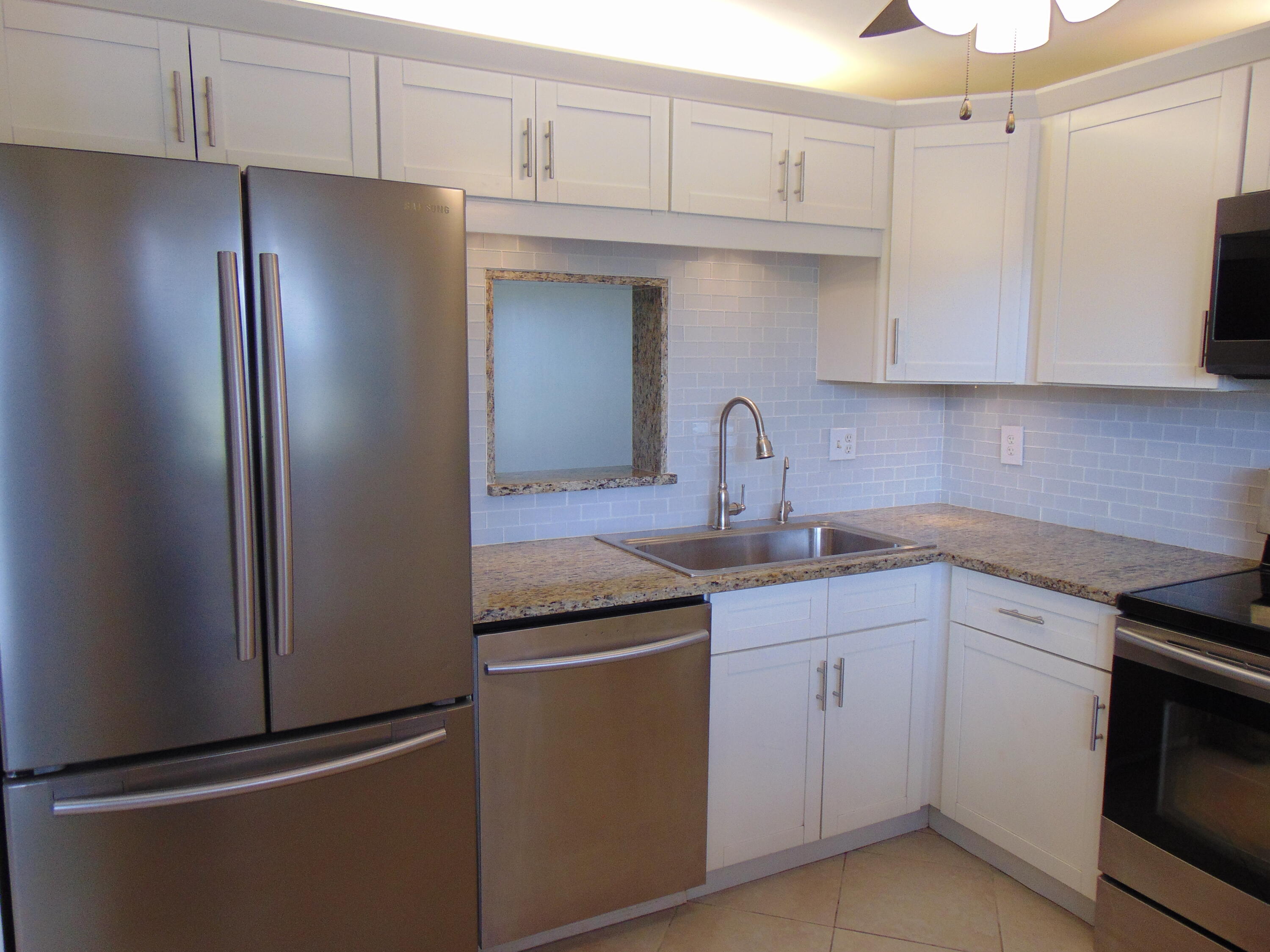 a kitchen with stainless steel appliances a refrigerator sink and cabinets