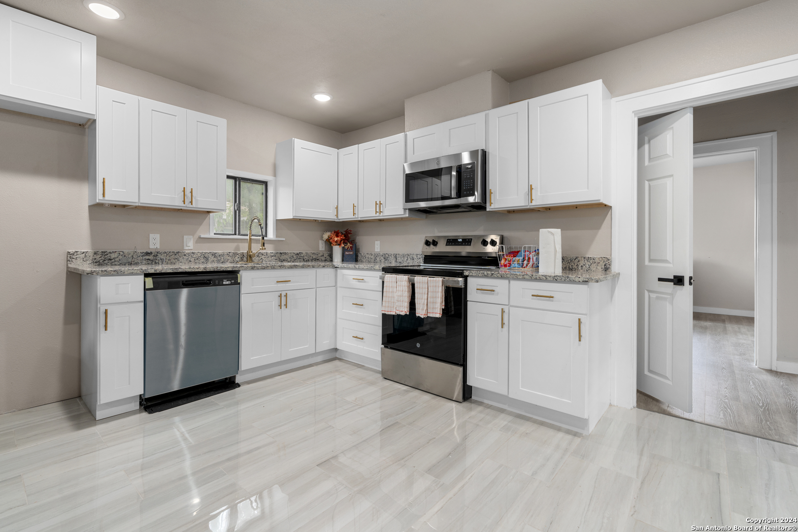 a kitchen with white cabinets stainless steel appliances and sink