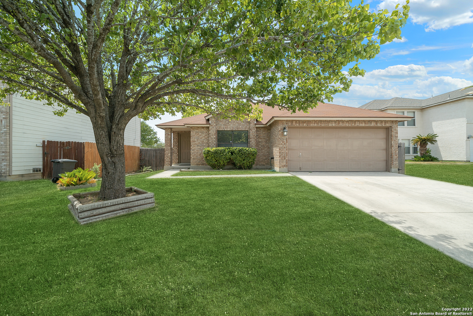 a front view of a house with a garden and yard