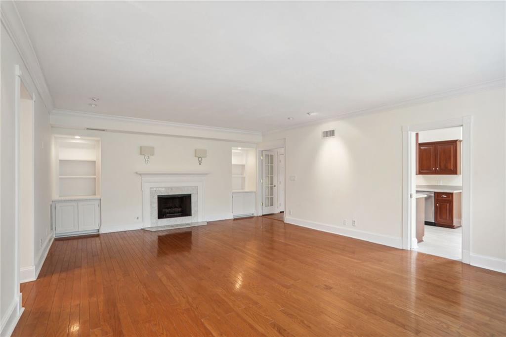 a view of empty room with wooden floor and fireplace