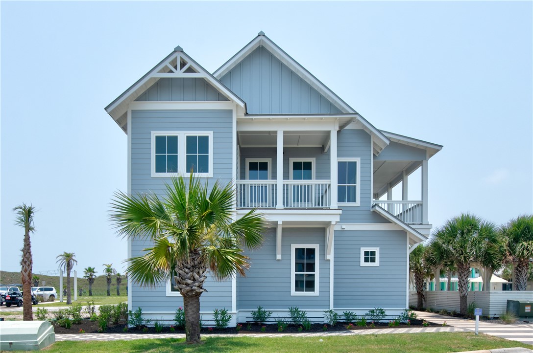 a front view of a house with a yard and palm trees