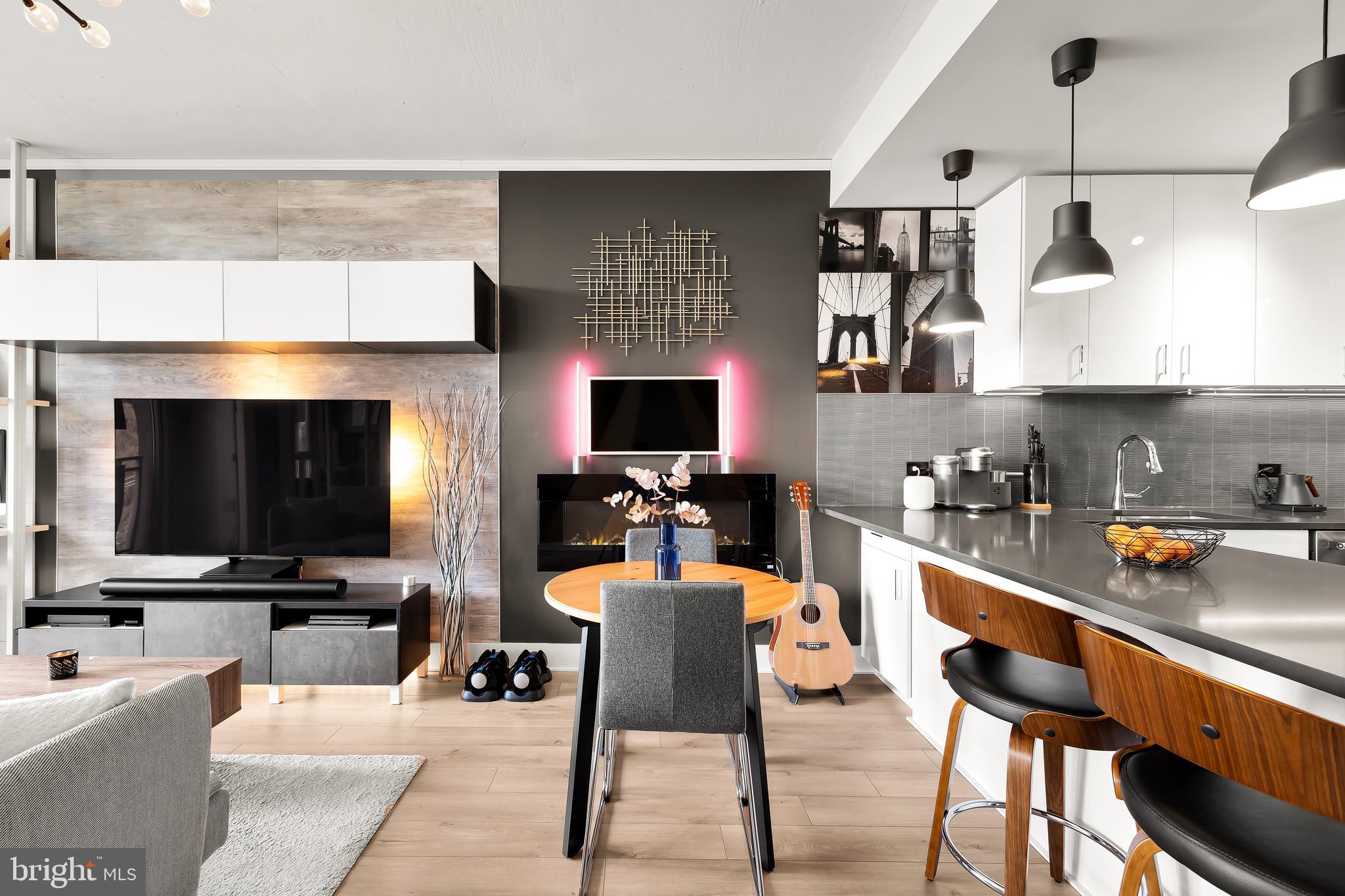 a view of kitchen with stainless steel appliances kitchen island granite countertop dining room and wooden floor