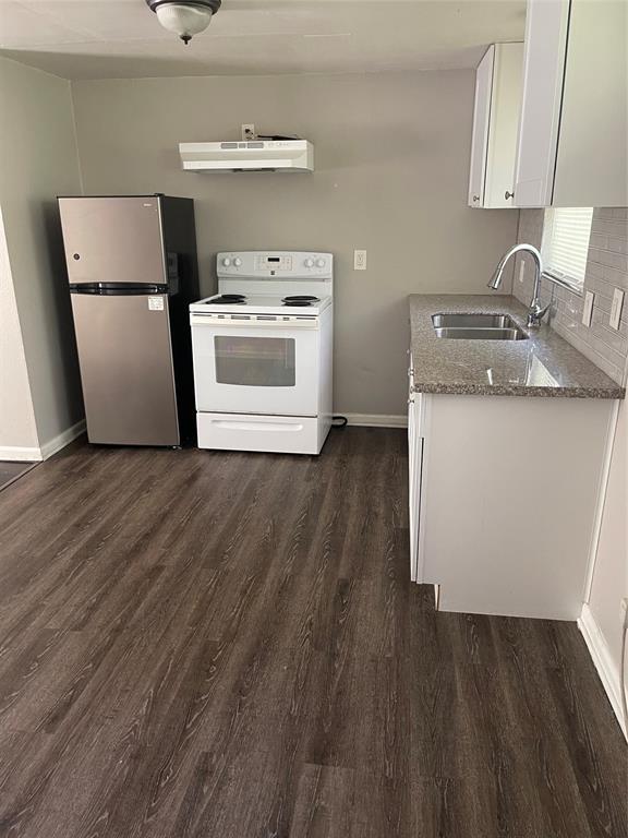 a kitchen with a sink a refrigerator and a stove top oven