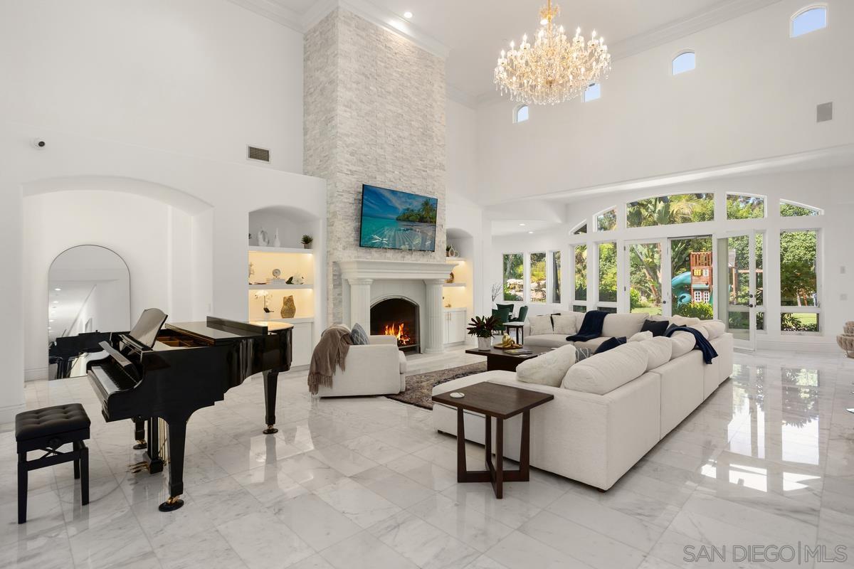 a living room with furniture a fireplace and a chandelier