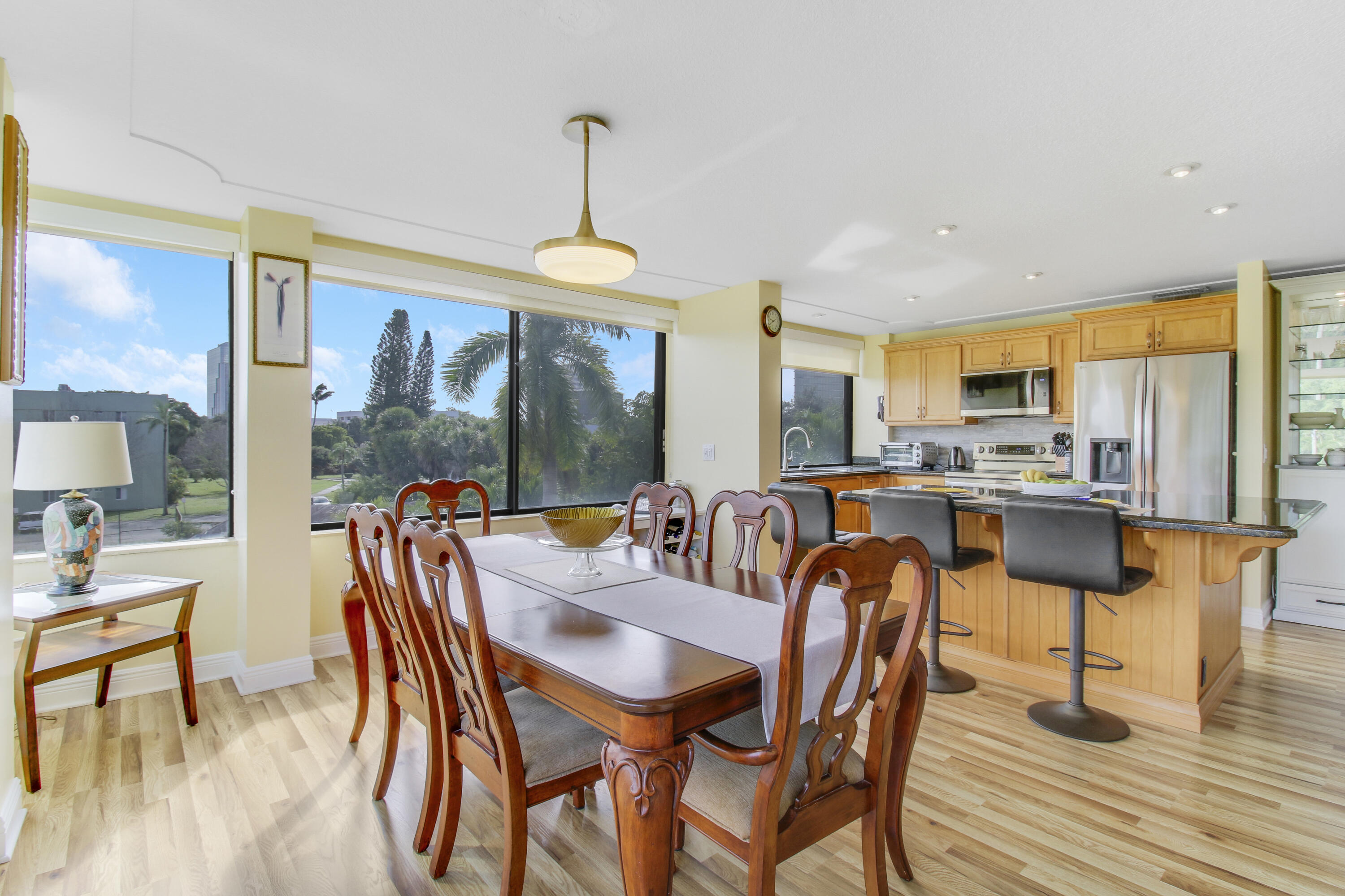 a view of a dining room and livingroom with furniture wooden floor a chandelier