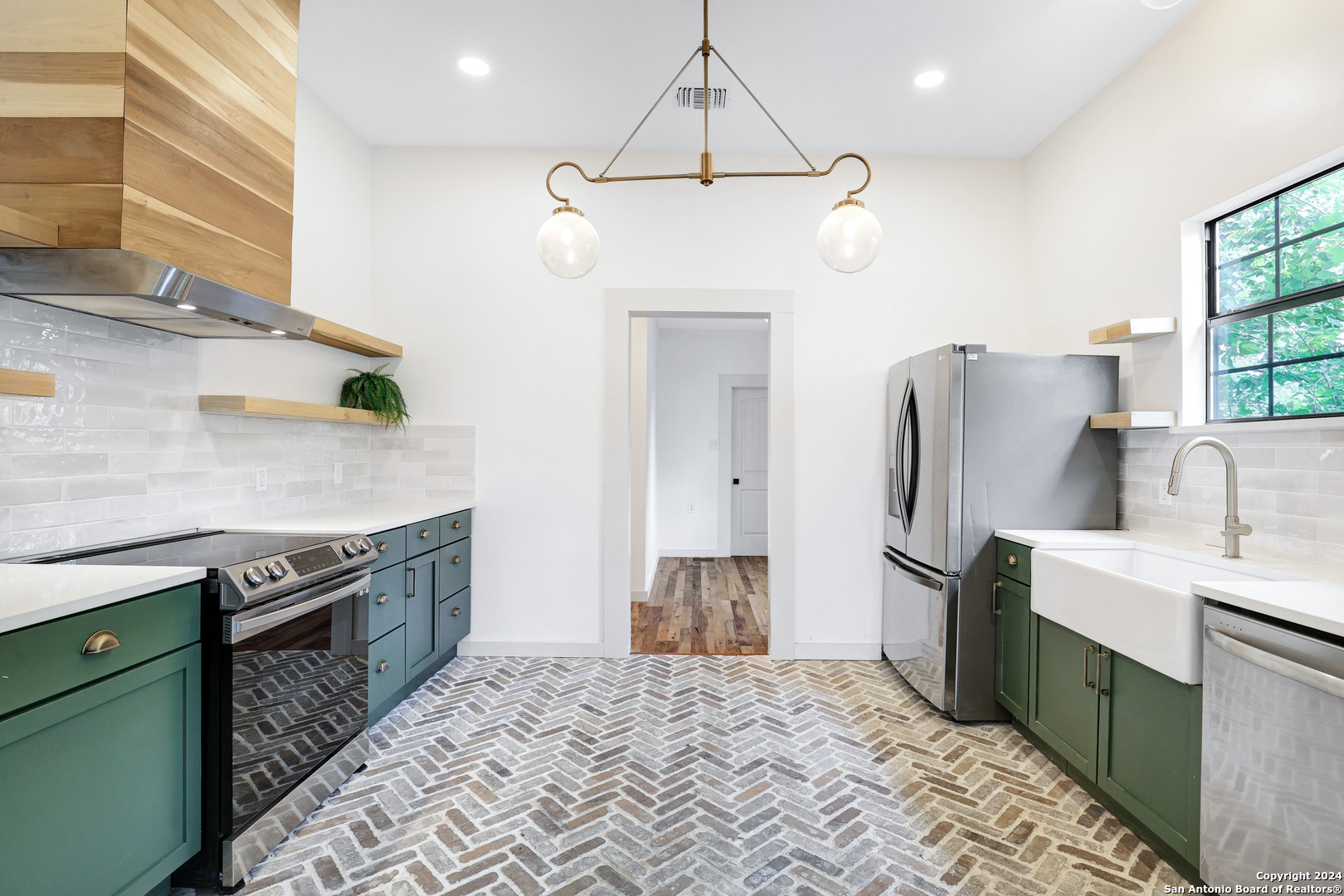 a kitchen with stainless steel appliances granite countertop a sink a stove and a refrigerator