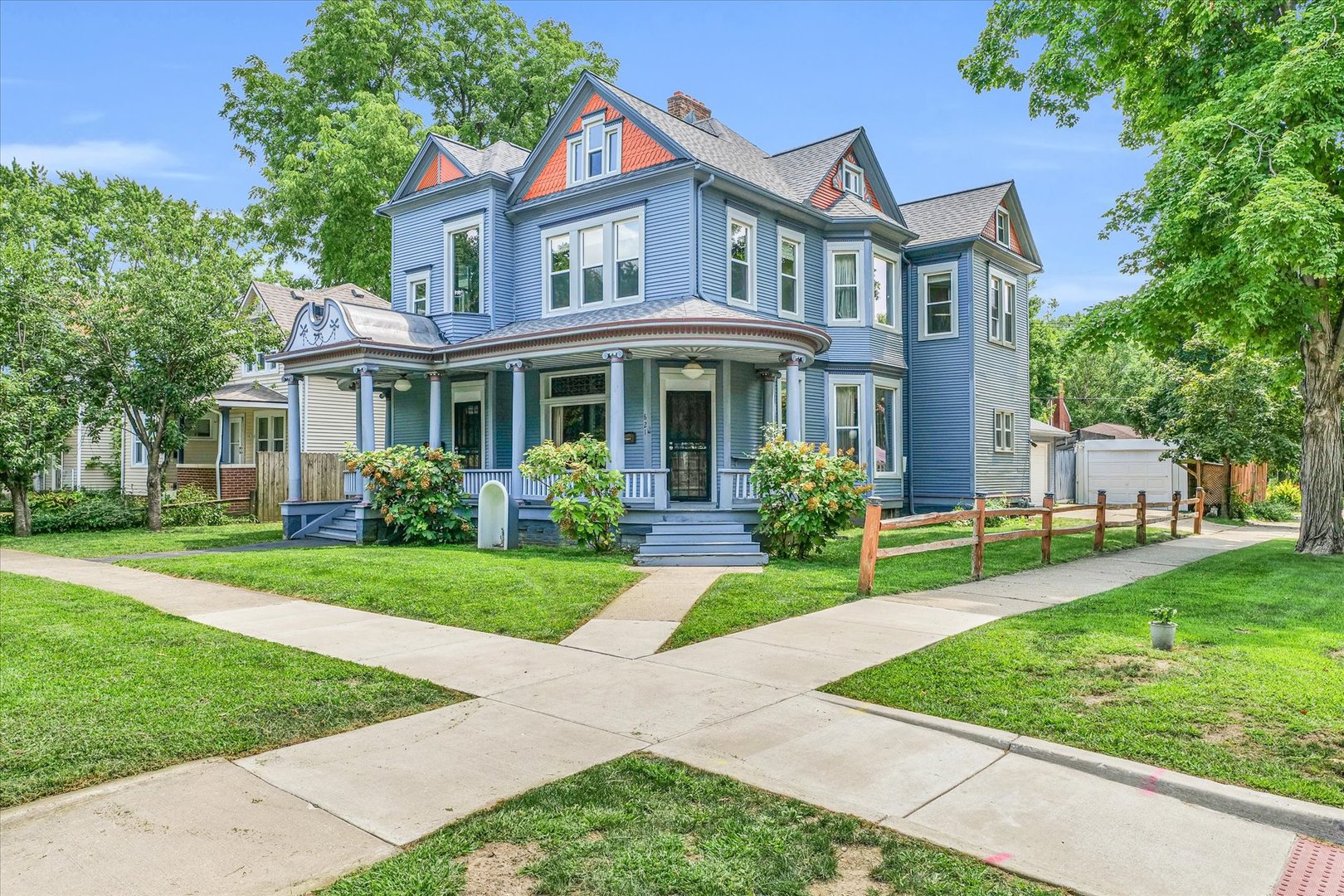 a front view of a house with a yard and potted plants