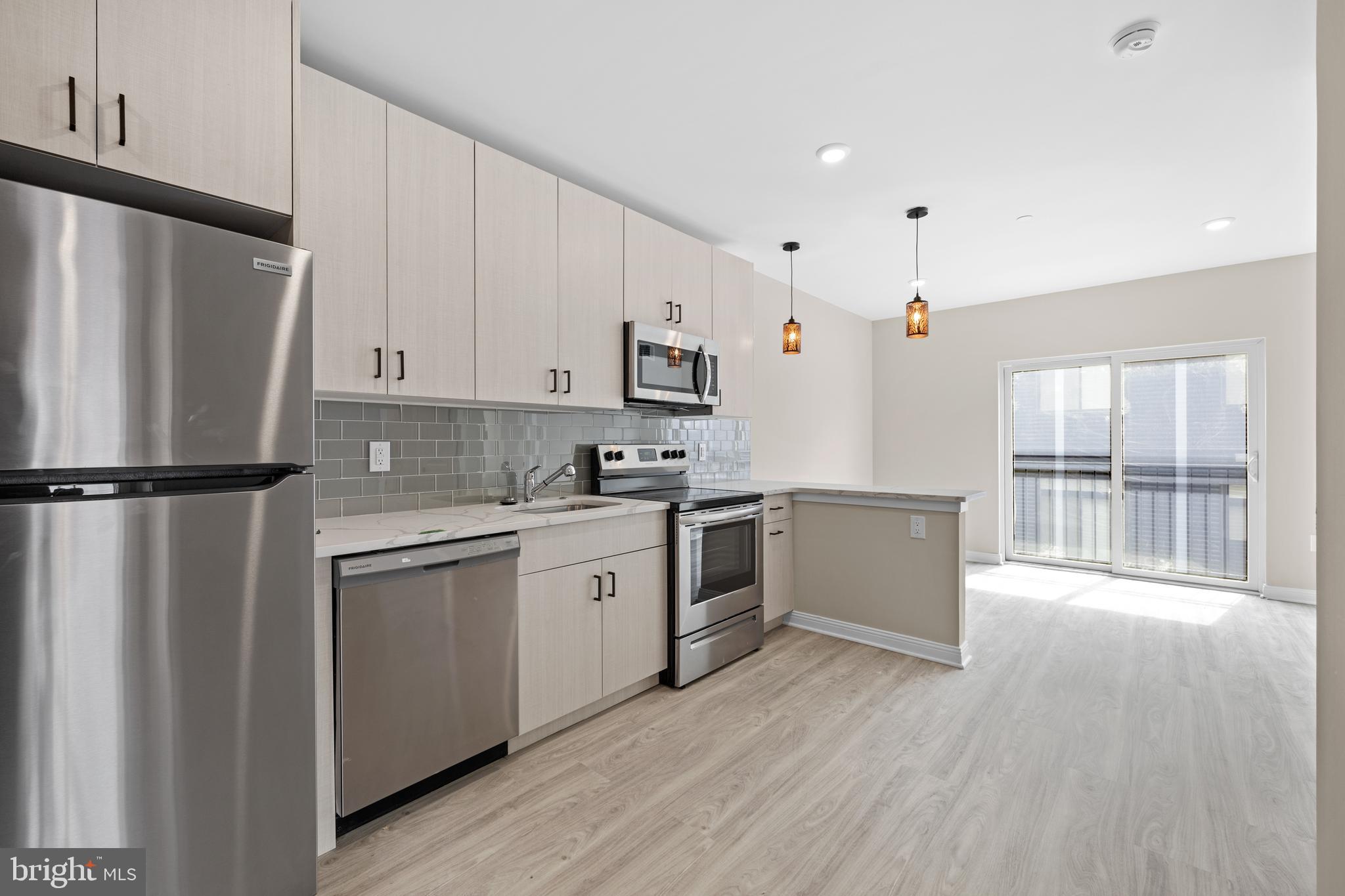 a kitchen with granite countertop a refrigerator stove top oven and sink