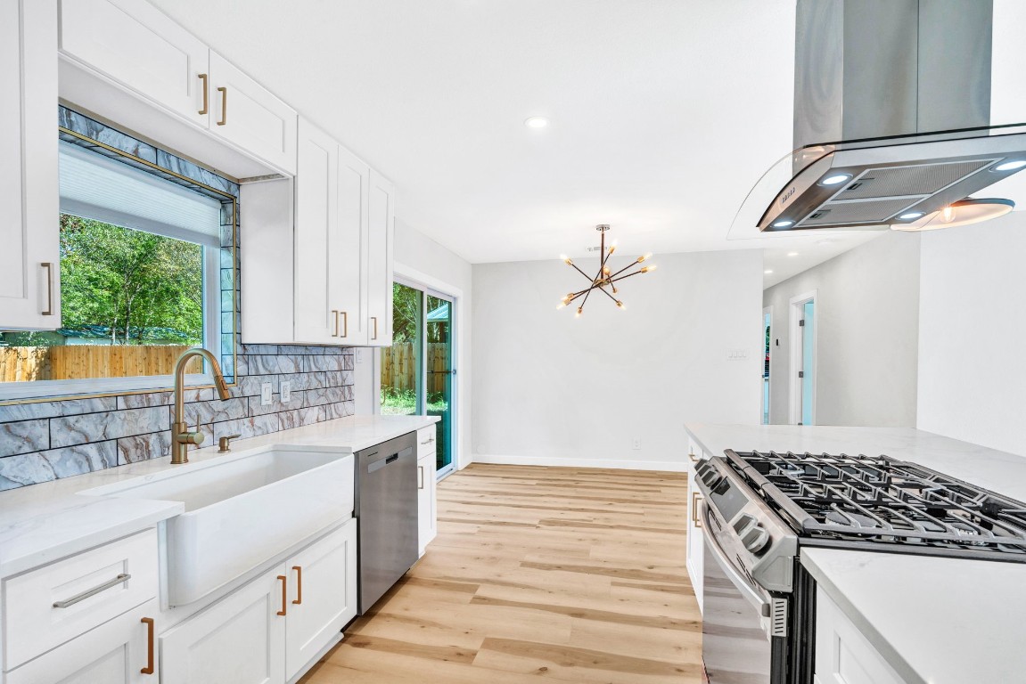 a kitchen with a stove and white cabinets