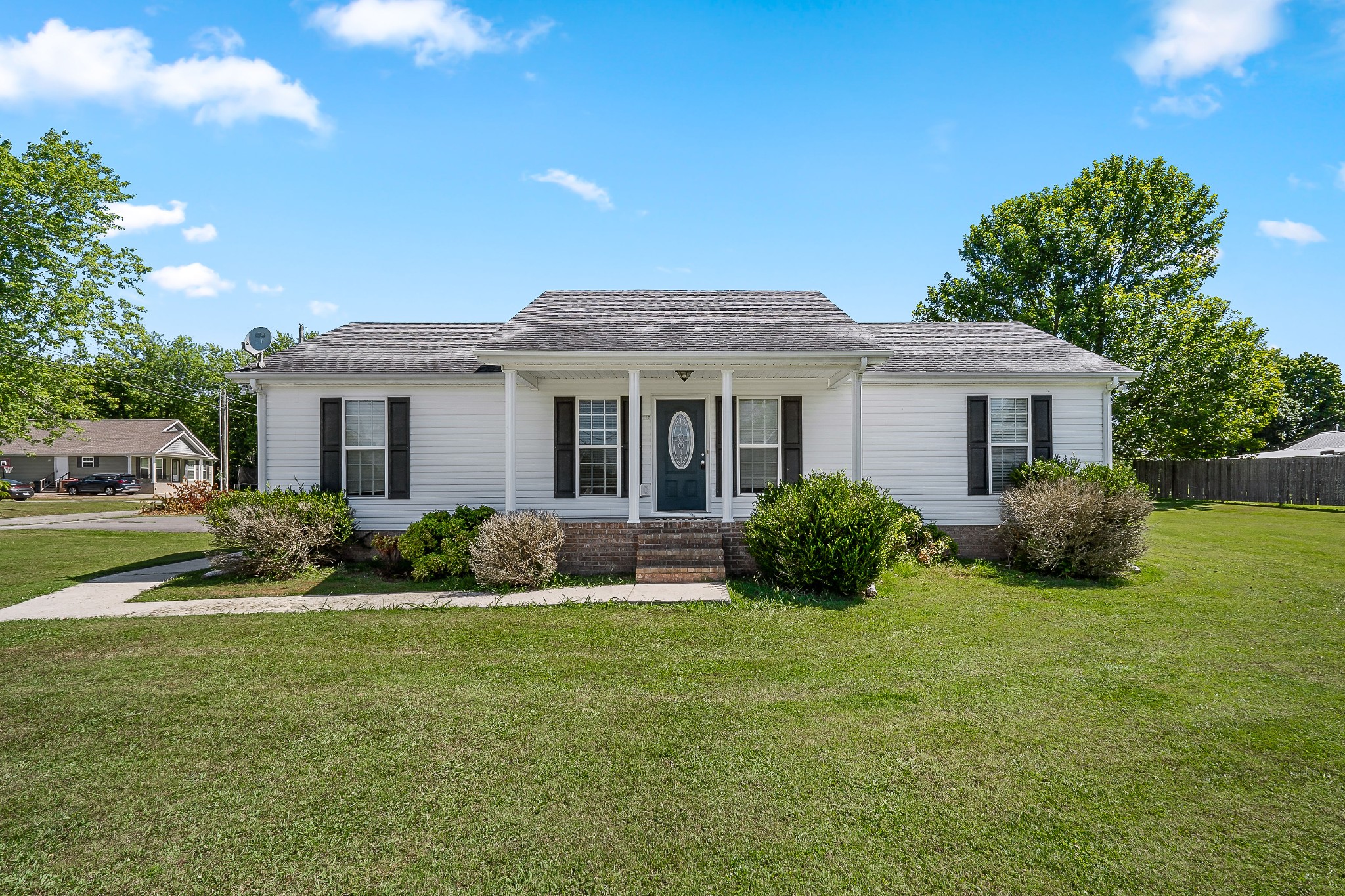 a front view of a house with yard and green space