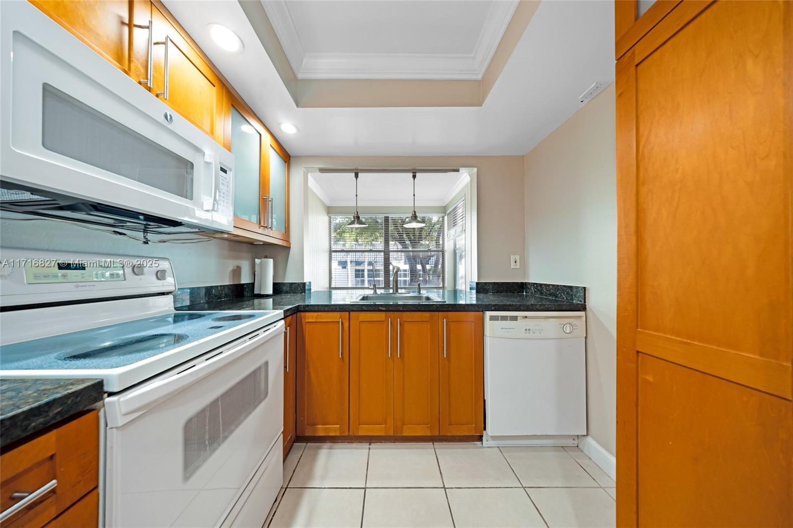 a kitchen with stainless steel appliances granite countertop a refrigerator a sink and white cabinets