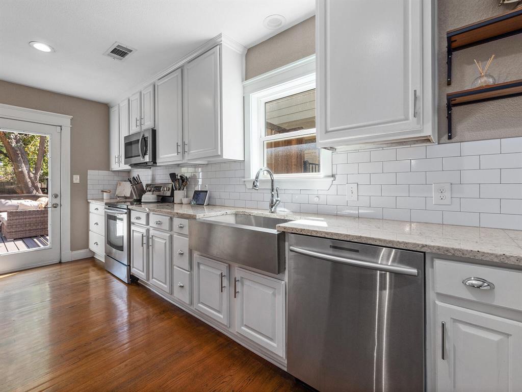 a kitchen with stainless steel appliances granite countertop a sink stove and cabinets