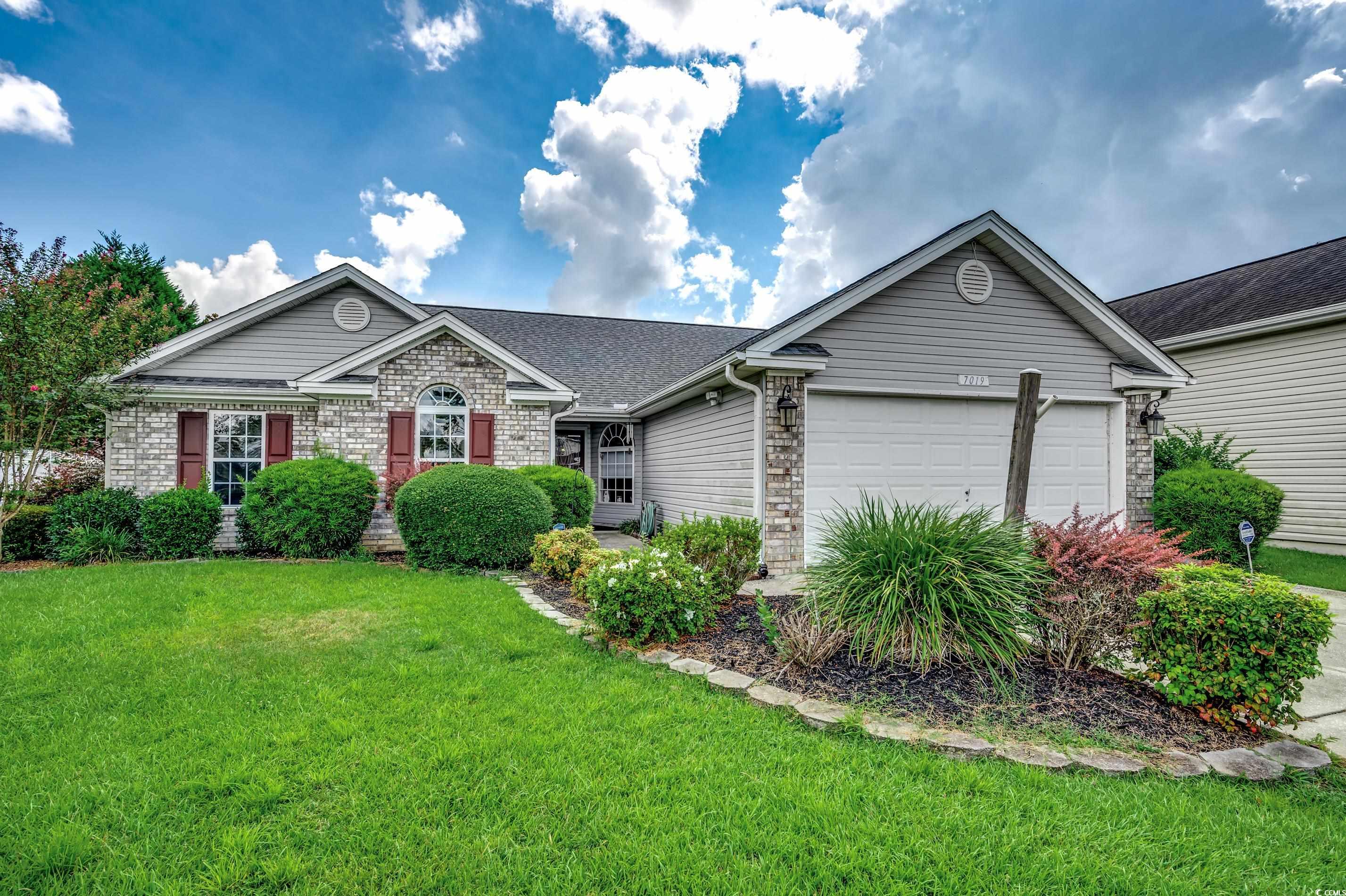 Ranch-style home with a front yard and a garage