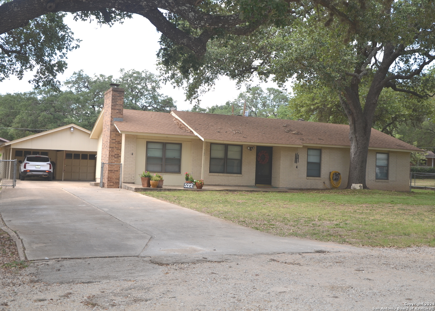 a front view of a house with a garden and trees