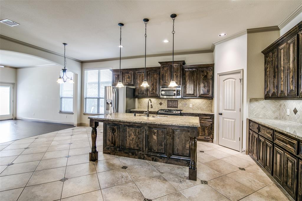 a kitchen with stainless steel appliances granite countertop a sink and a refrigerator