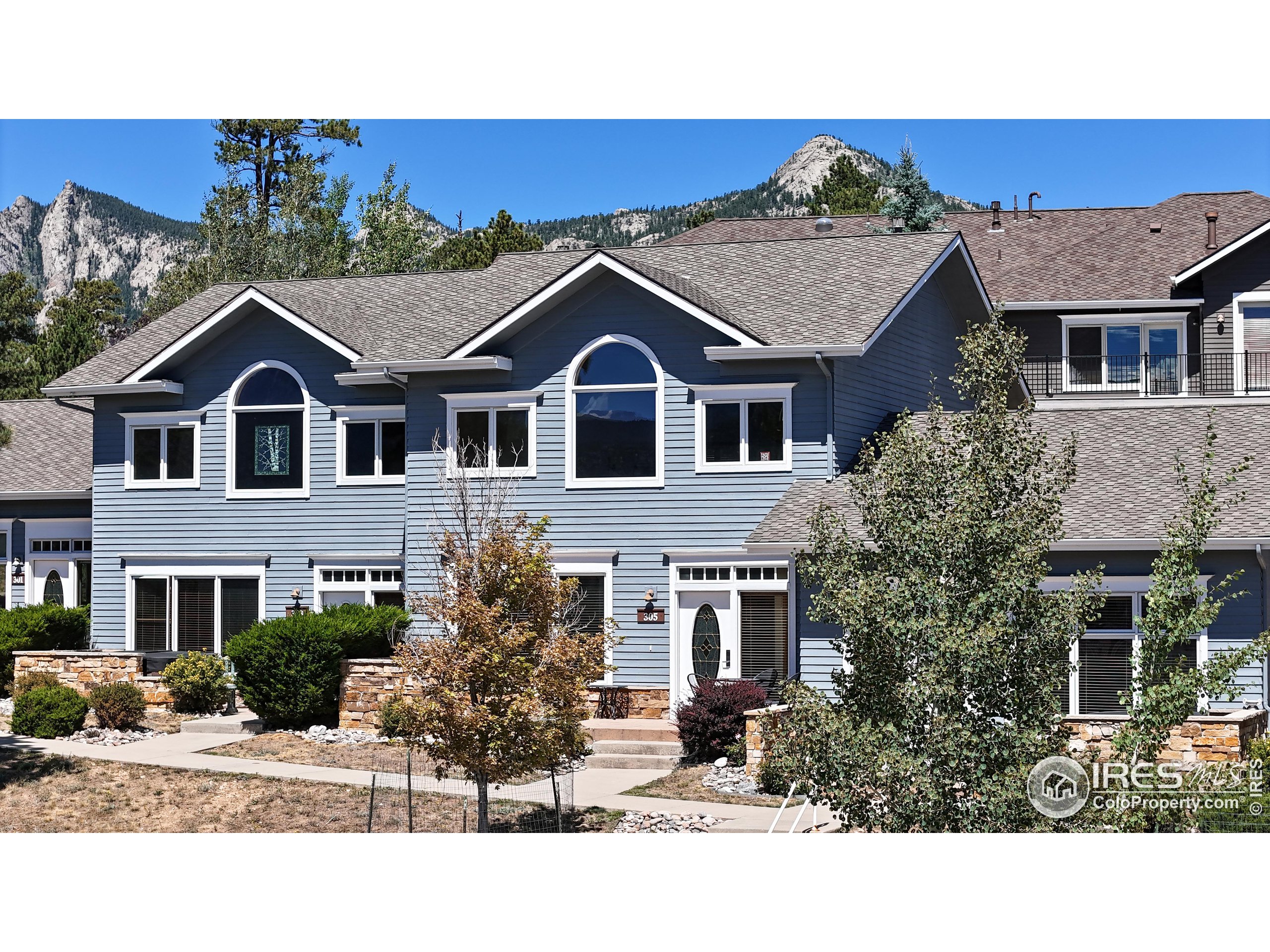 a view of a big house with a big yard and large trees