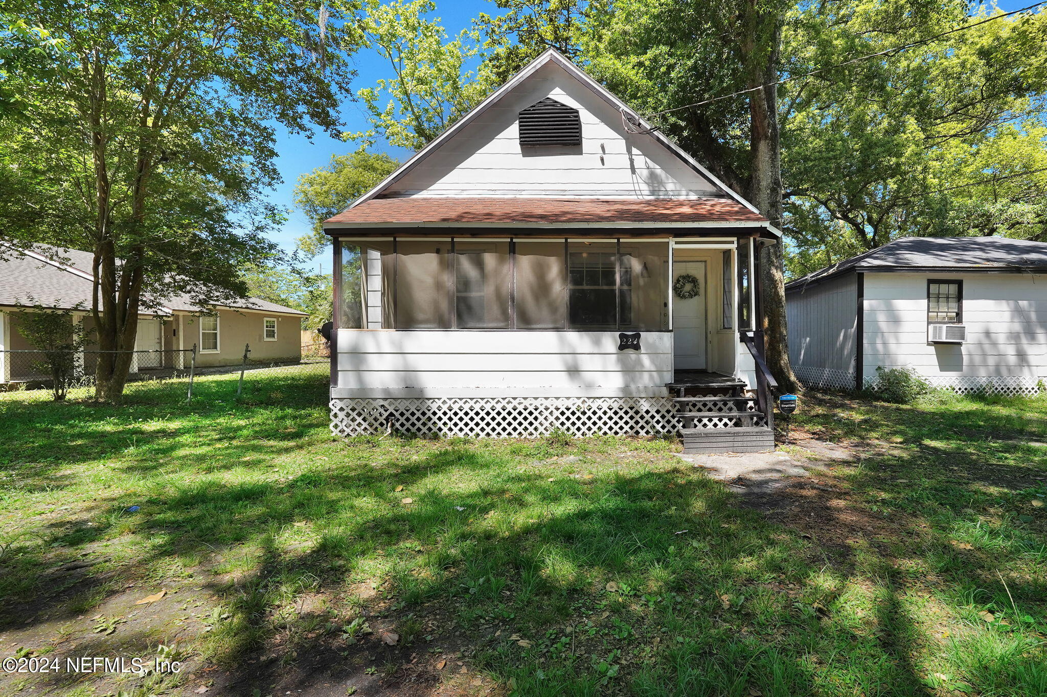 a view of a house with backyard and a tree