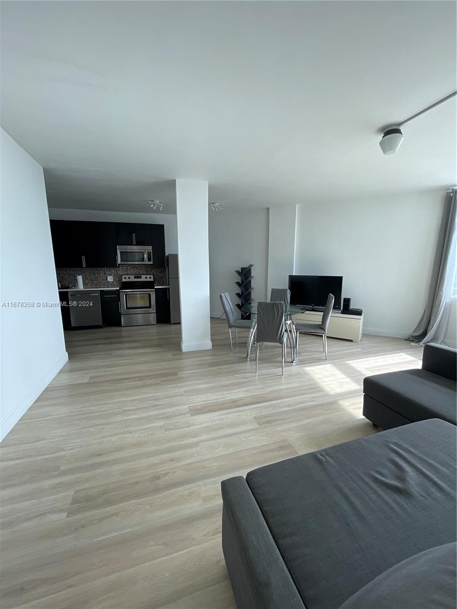 a view of kitchen with furniture and wooden floor