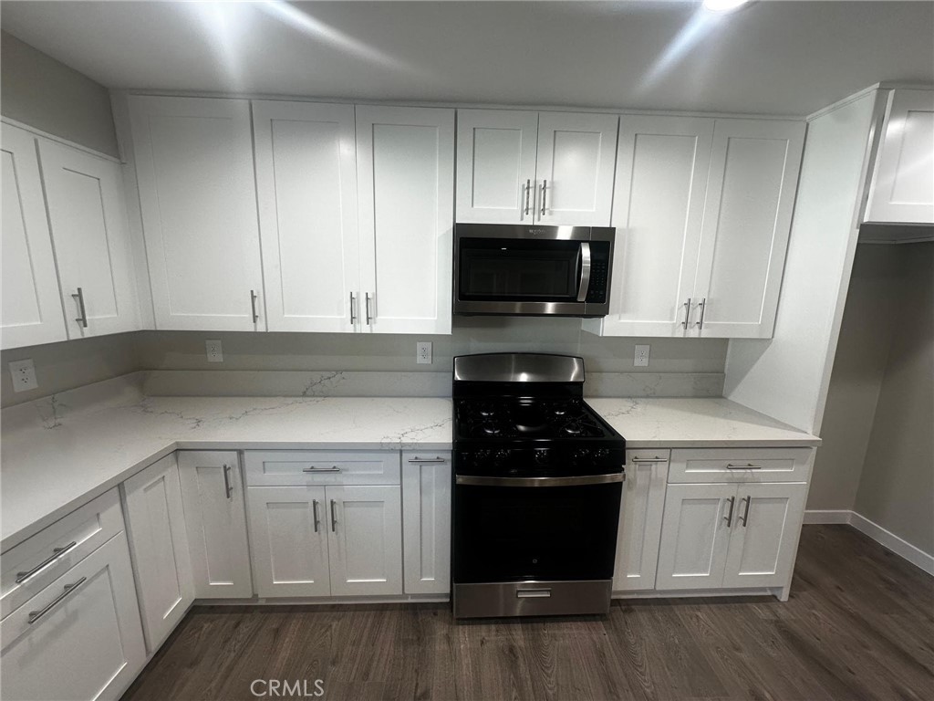 a kitchen with a sink stove and microwave