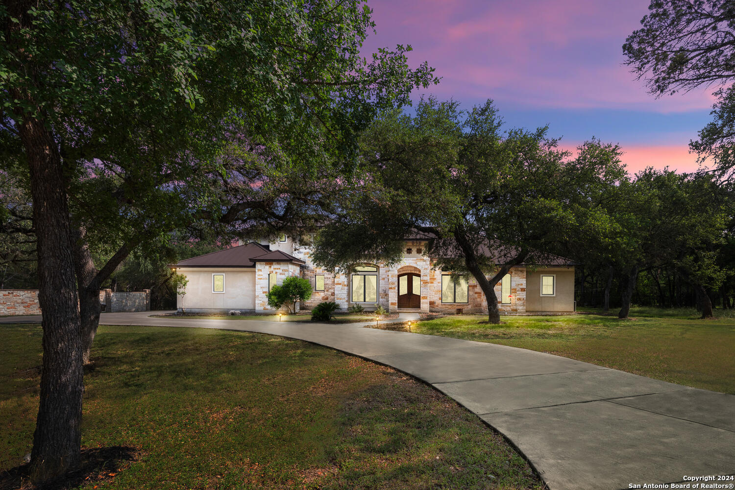 a front view of a house with a yard and trees