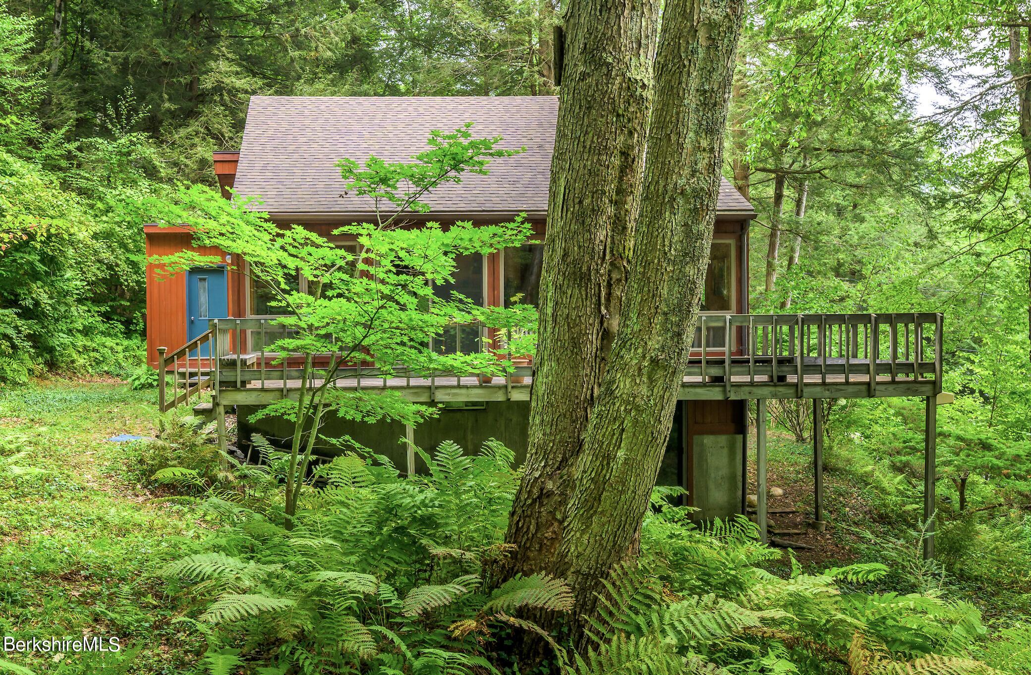 an aerial view of residential house with outdoor space and trees all around