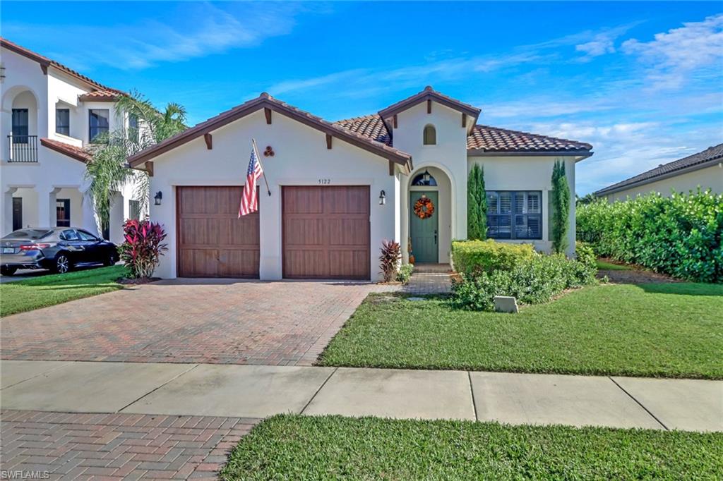 Mediterranean / spanish-style home featuring a garage and a front yard