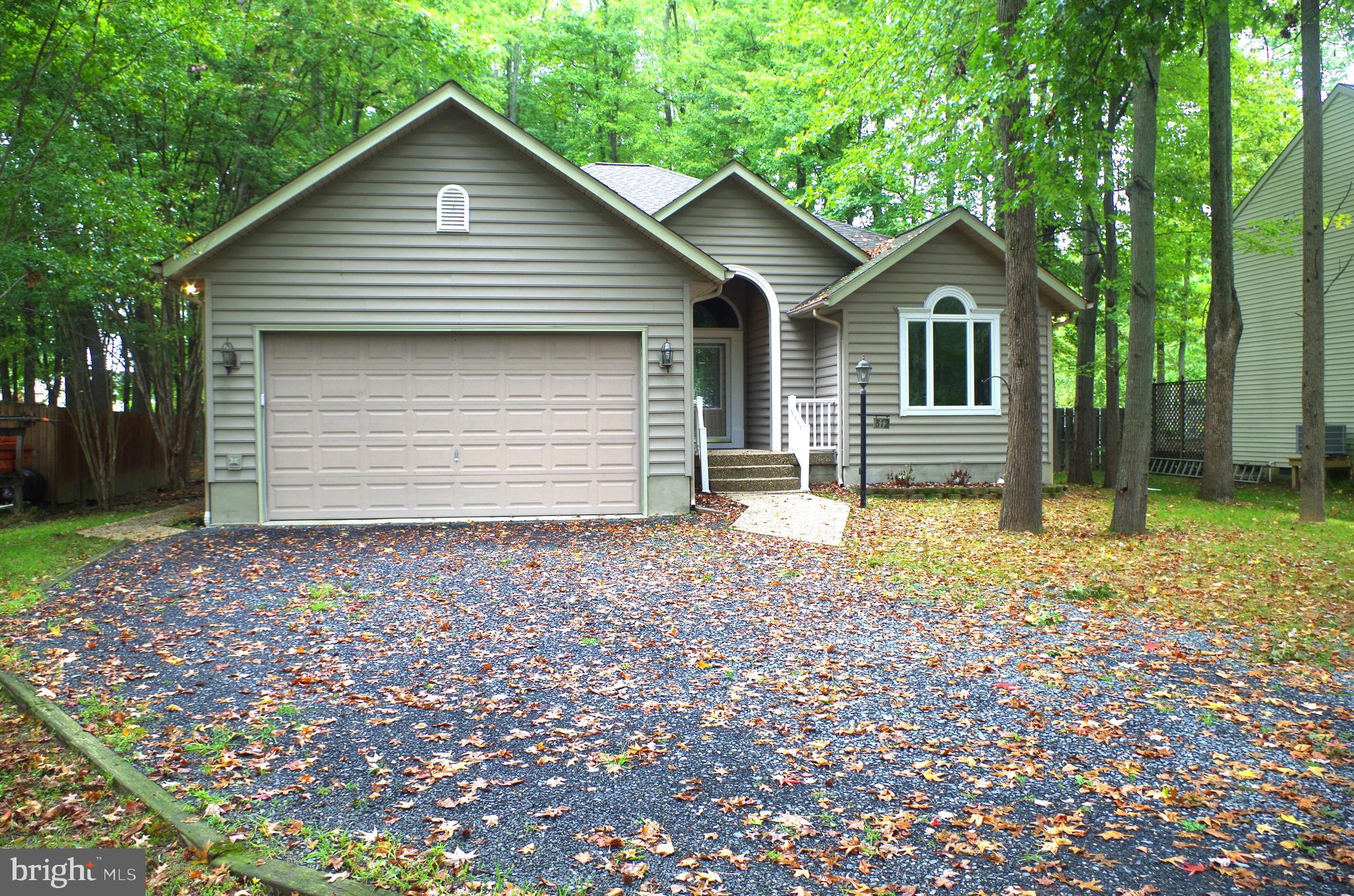 a view of a house with a yard and large tree