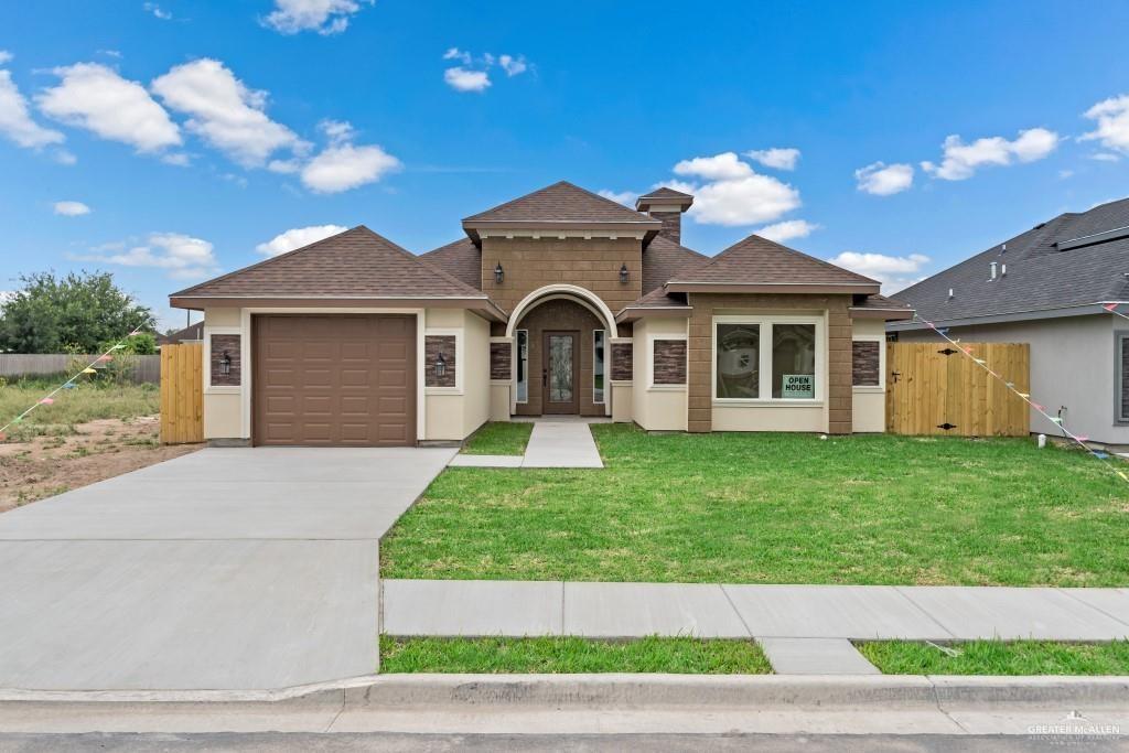 View of front of home with a front yard and a garage