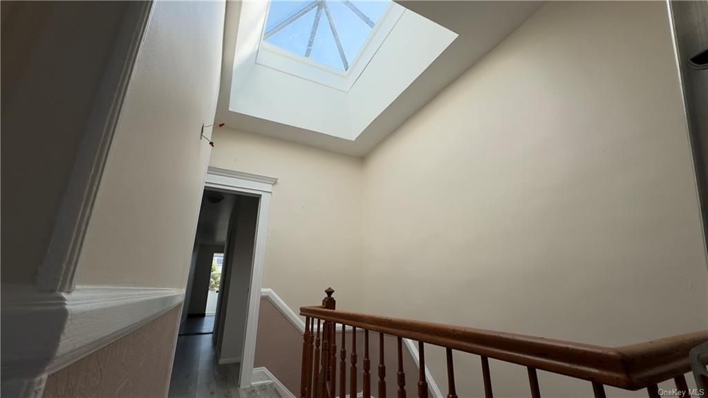 Stairway with a skylight and hardwood / wood-style flooring