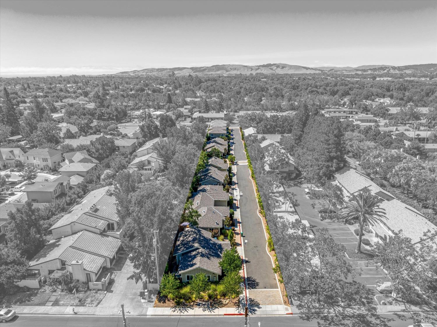 an aerial view of house with yard and mountain view in back