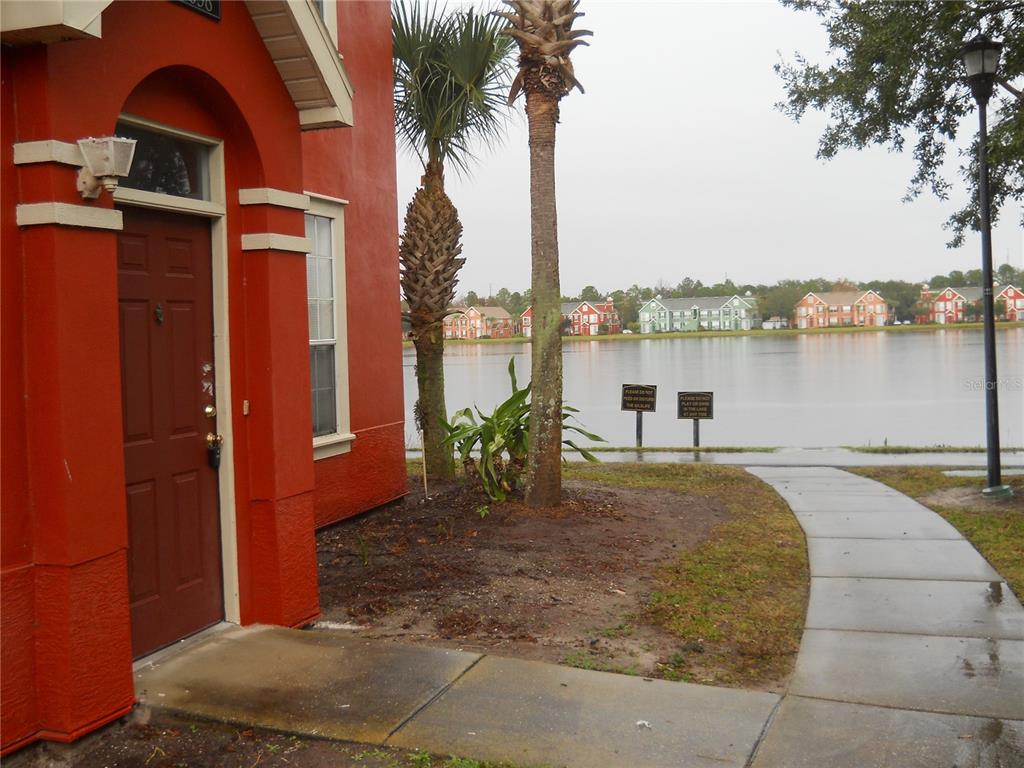 a view of a lake with couches chairs under an umbrella