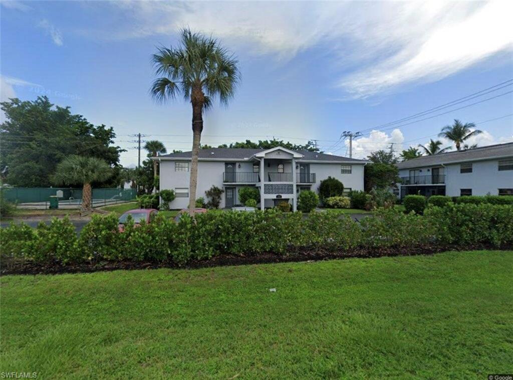 a front view of a house with a yard and potted plants