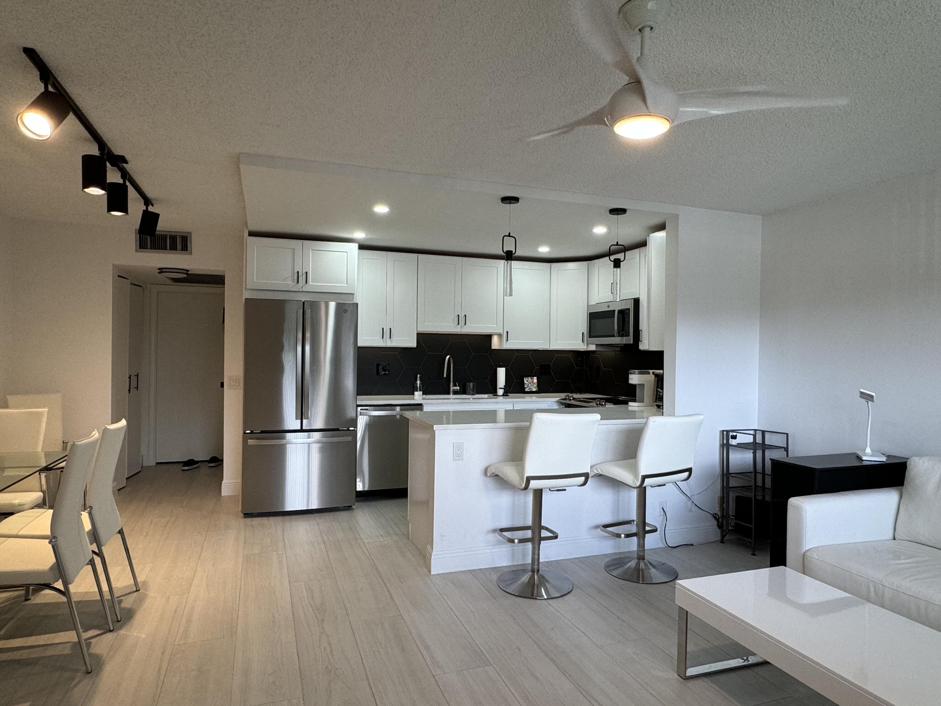 a view of kitchen with stainless steel appliances refrigerator stove dining table and chairs