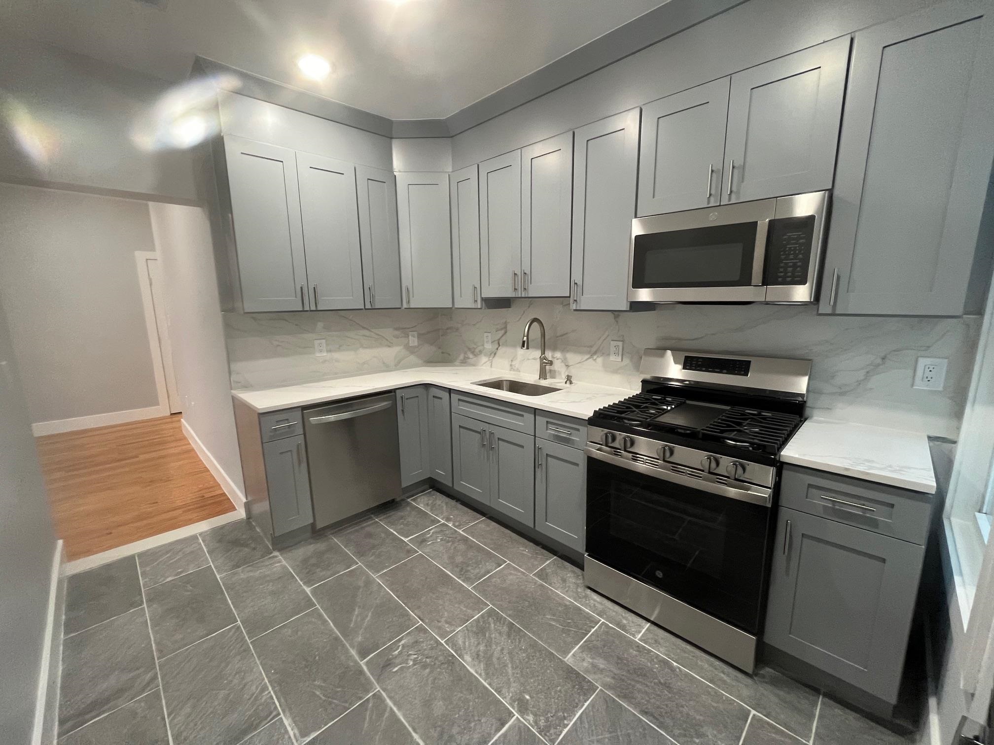 a kitchen with a sink a stove and cabinets