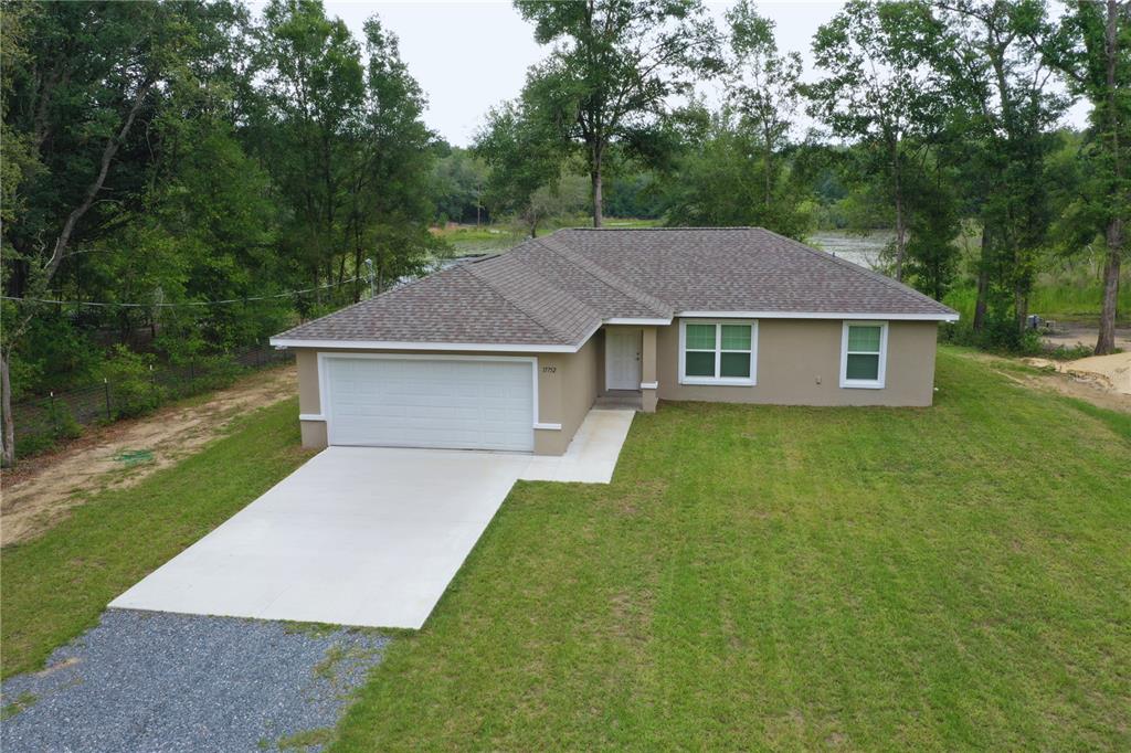 a front view of a house with a yard and trees