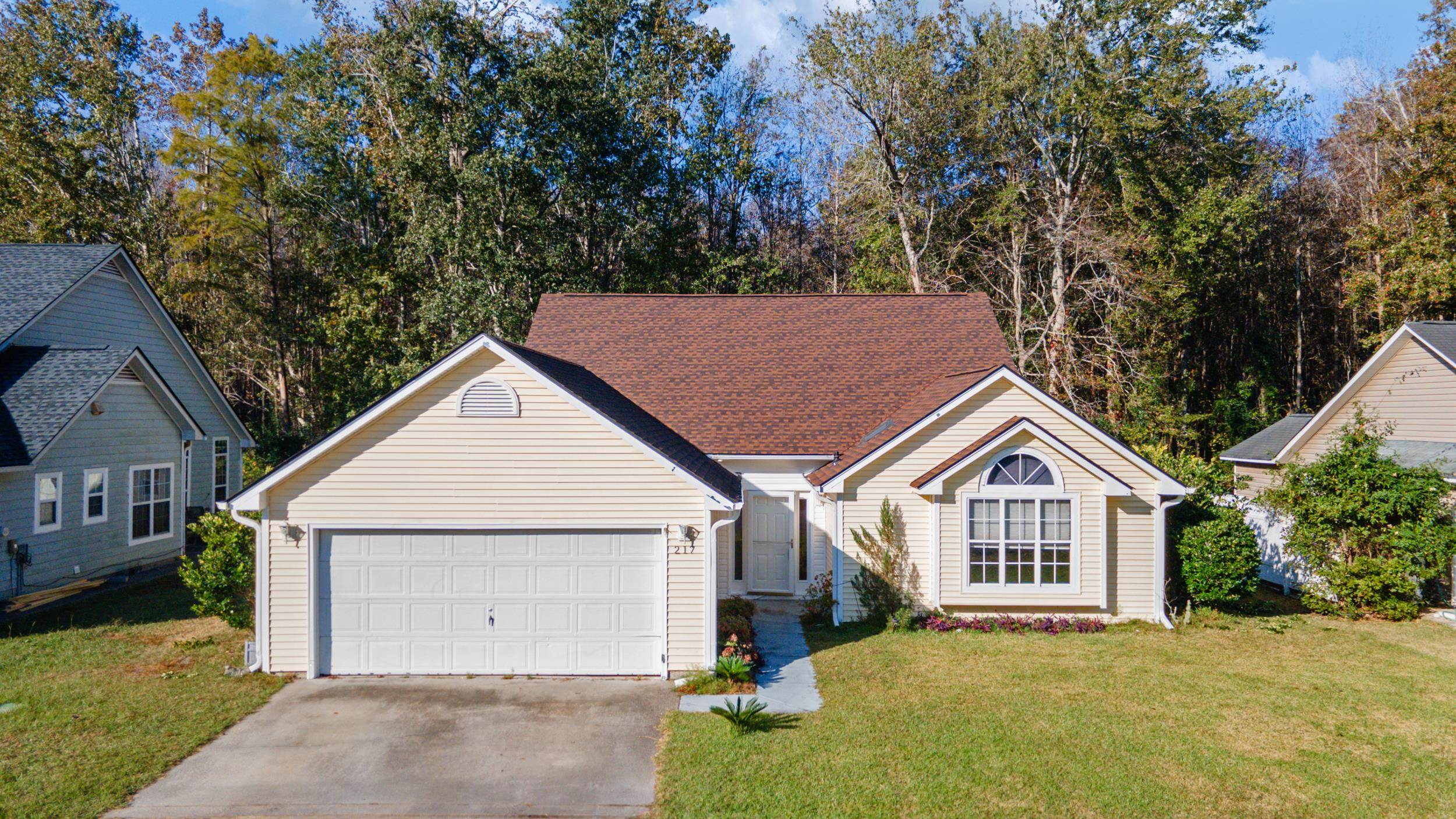 Single story home featuring a front lawn and a gar