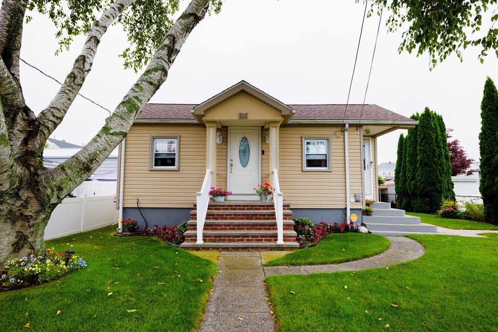 a front view of a house with a yard and trees