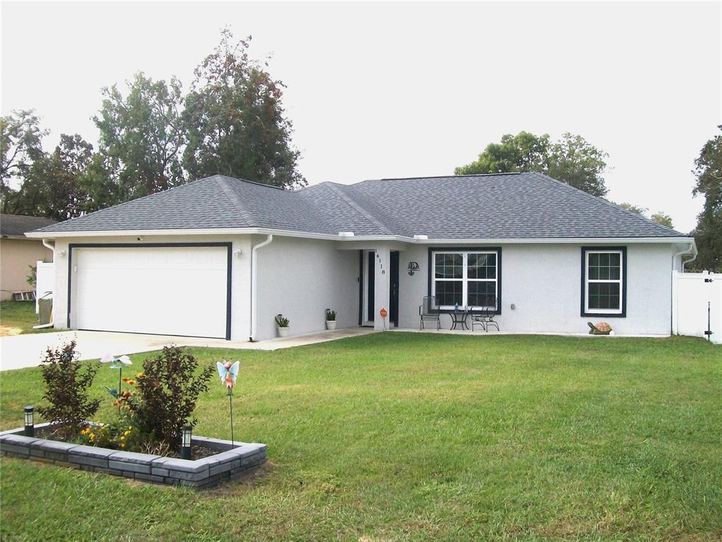 a front view of a house with a garden and yard