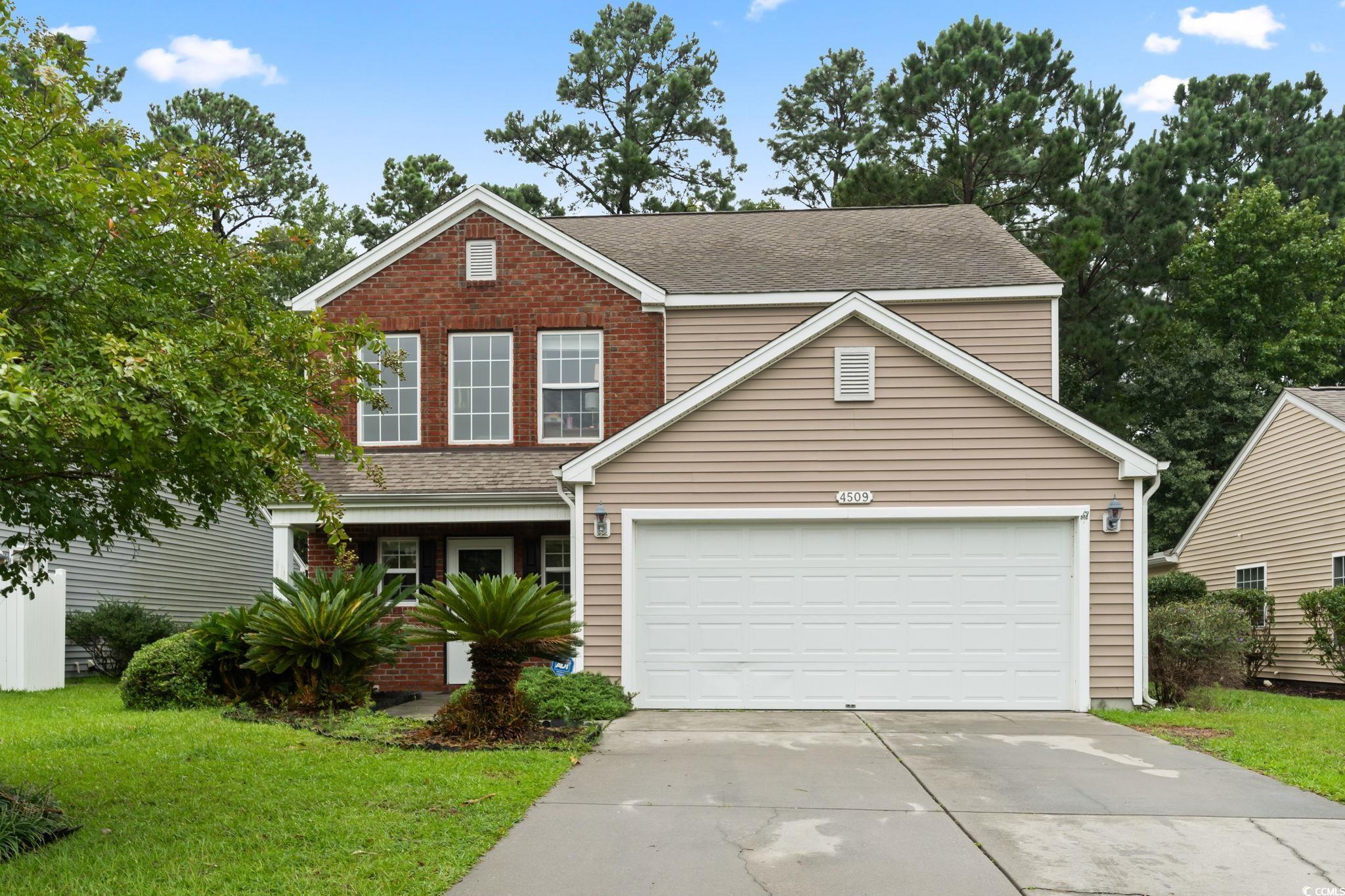 View of front of house with a front lawn and a gar