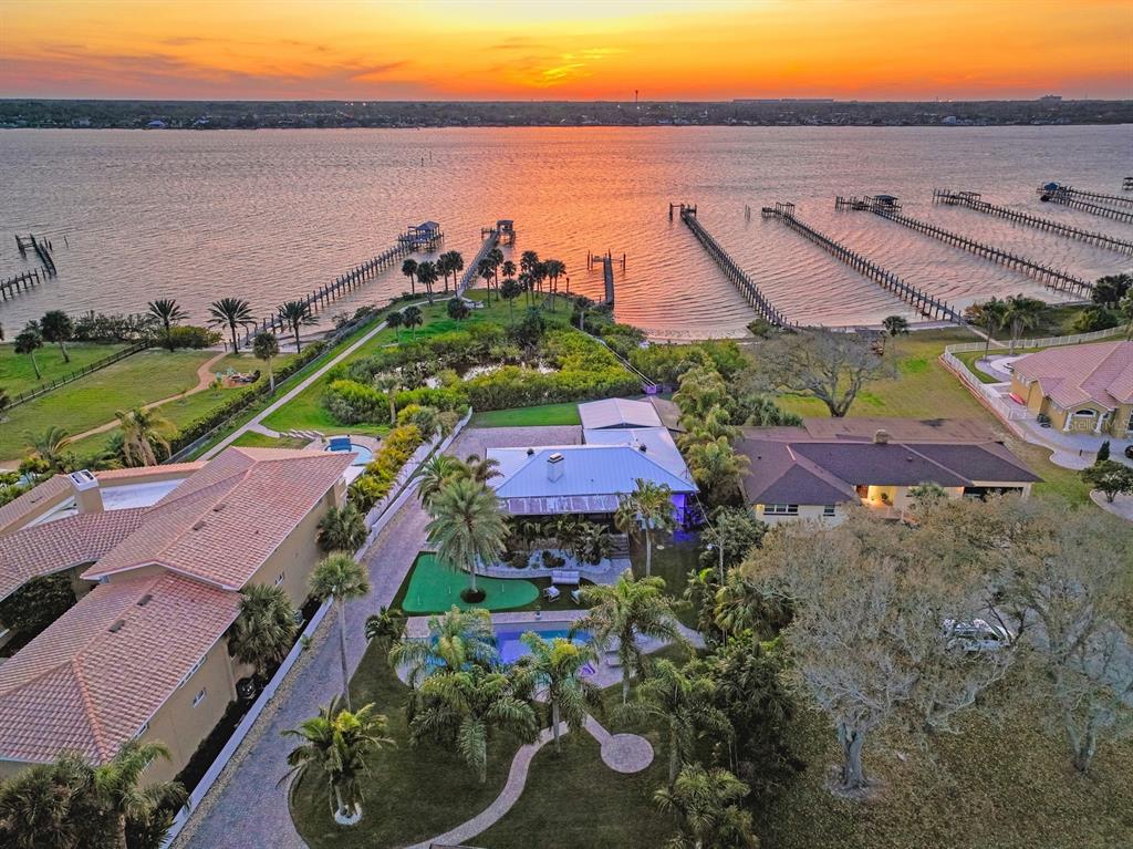 an aerial view of a house with a garden and lake view