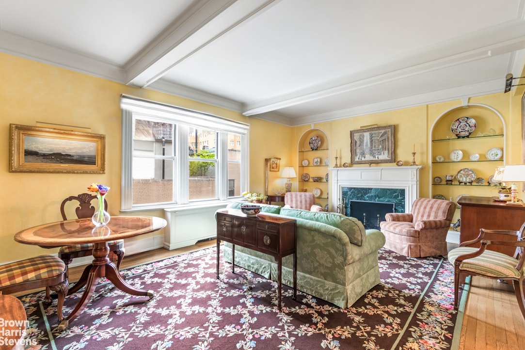 a living room with furniture a fireplace and a large window