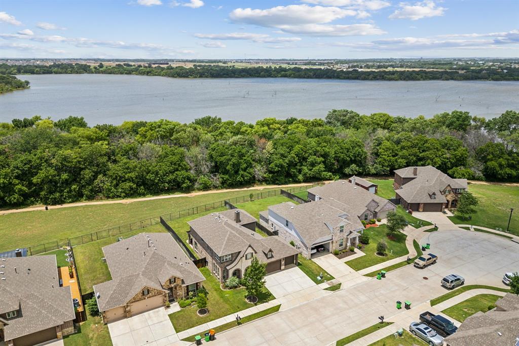 an aerial view of a residential house with outdoor space and lake view in back