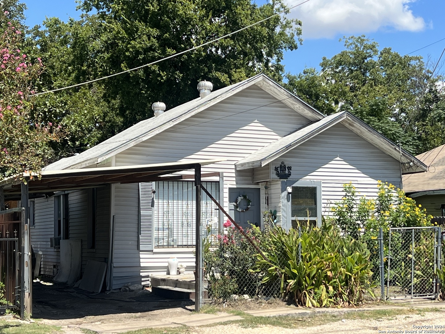 a front view of a house with a yard and potted plants