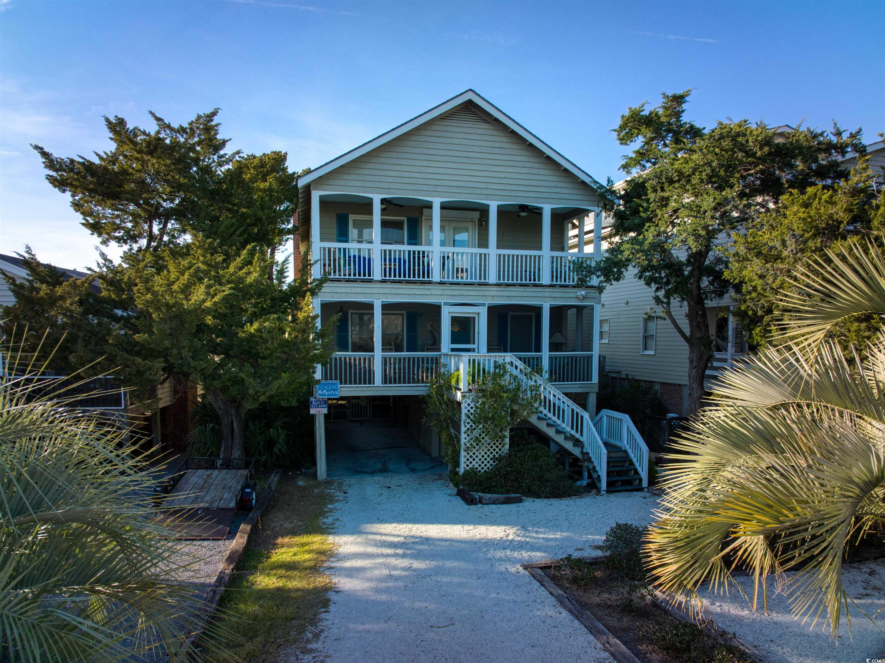 View of front of property with a balcony and a car