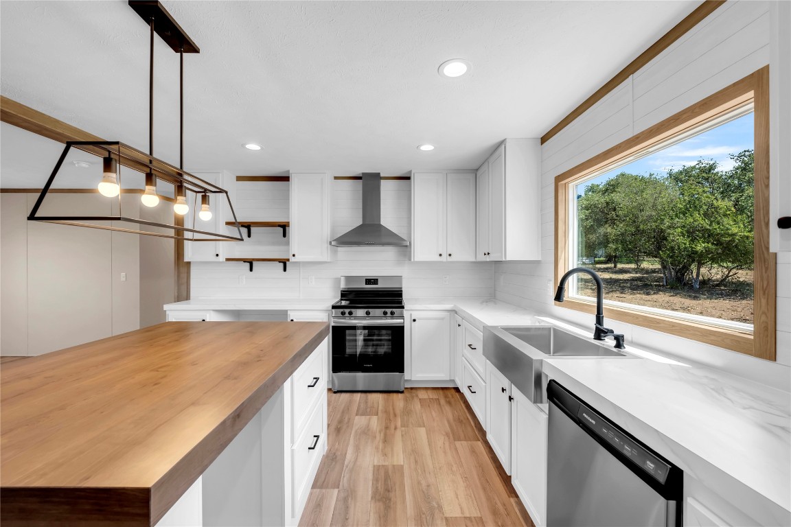 a kitchen with a sink a counter top space stainless steel appliances and cabinets