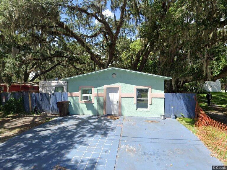 a front view of house with yard and trees in the background