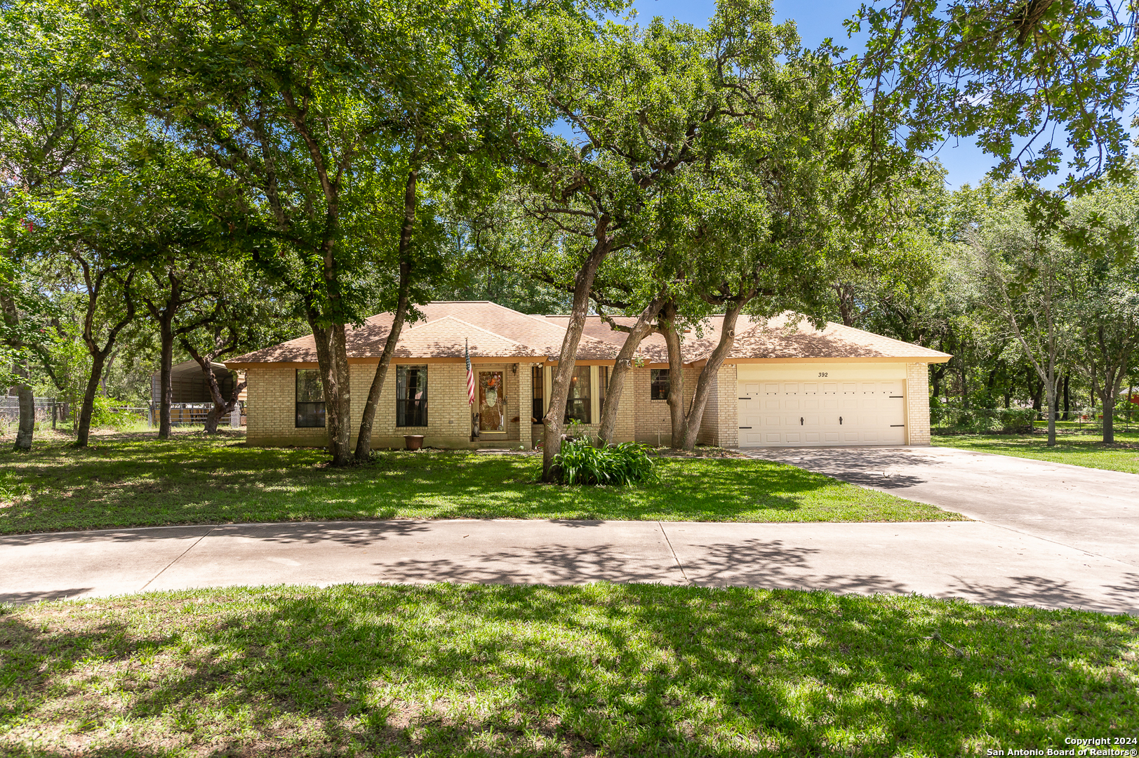 a front view of a house with a yard and trees