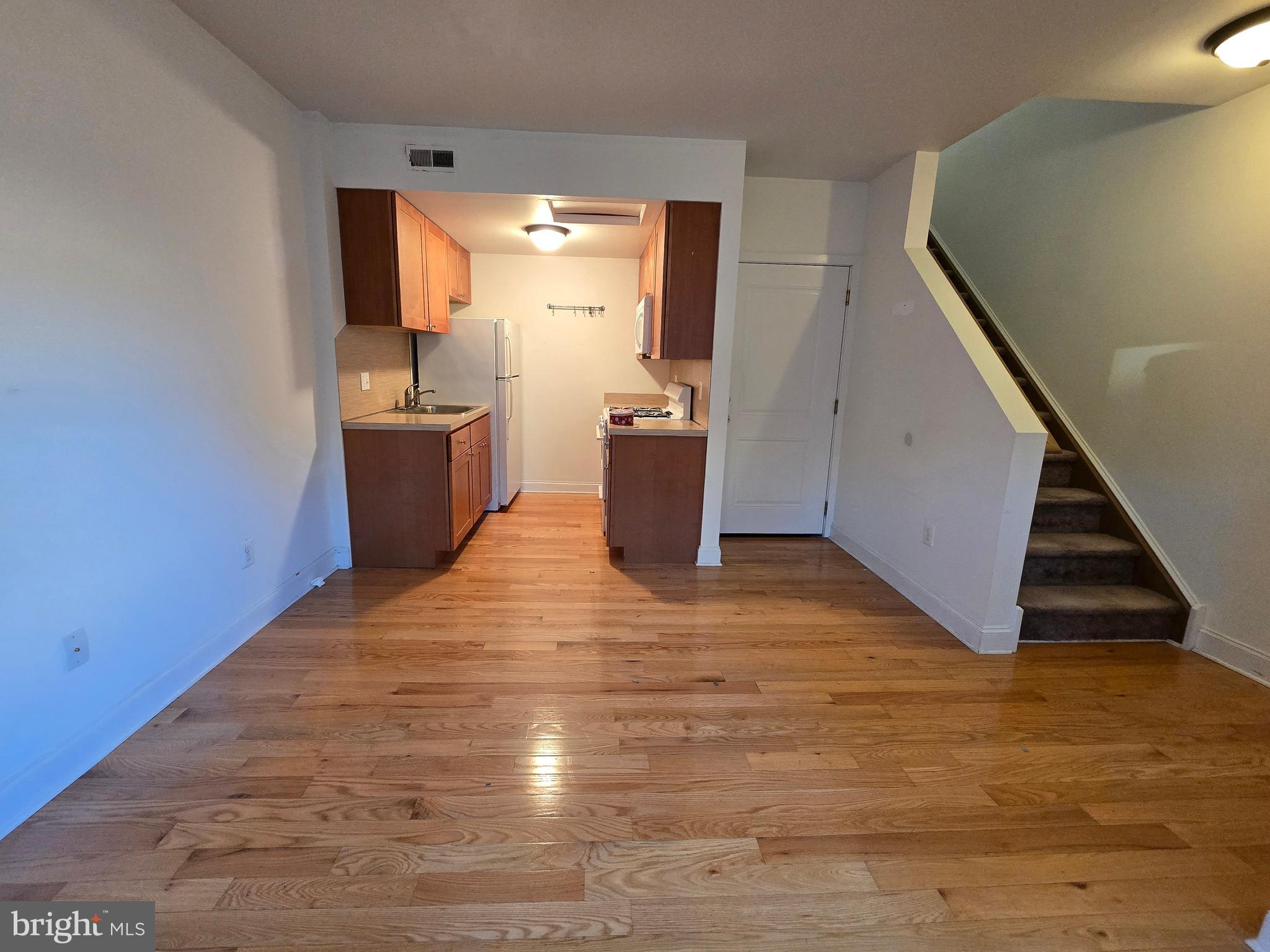 a view of a kitchen with wooden floor and electronic appliances