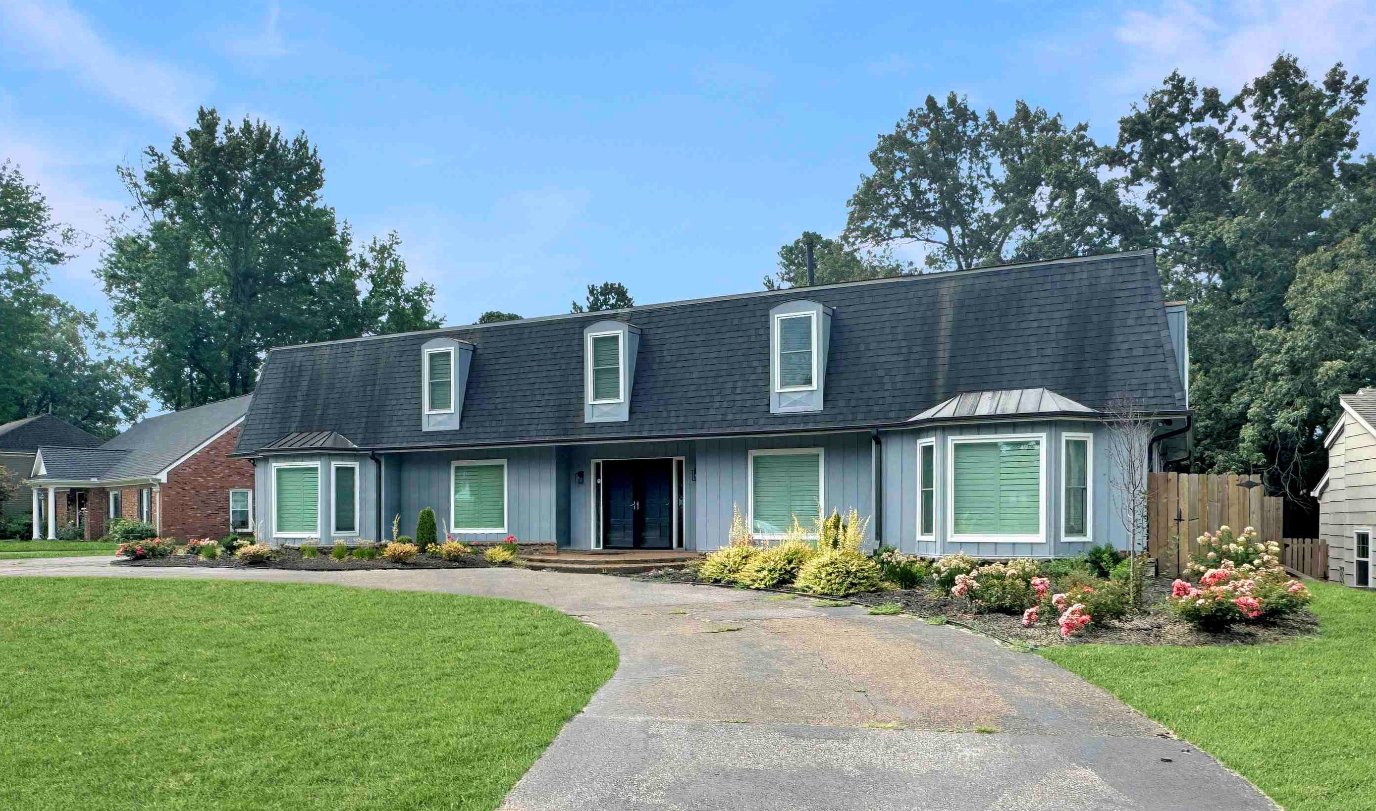 a front view of a house with a garden and porch