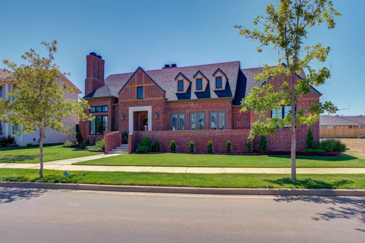 a front view of a house with a yard and potted plants